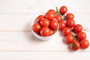 Cereza Tomates en el blanco de madera mesa foto