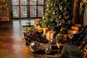 festivo Navidad exposición a hogar. decorado Navidad árbol con un montón de regalos de dorado, marrón y negro colores y grande plata disco pelotas foto