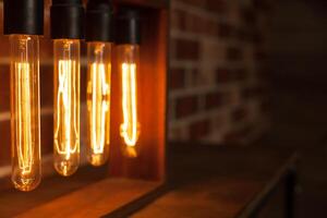 Light bulb lamp on dark red brick background with hotspot close up loft photo