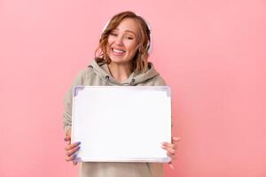 Woman holding empty blank board over pink background photo