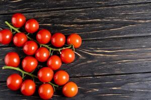 Cereza Tomates en el oscuro negro de madera mesa foto