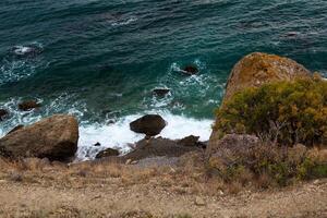 sea wave washes yellow beach of pebbles photo