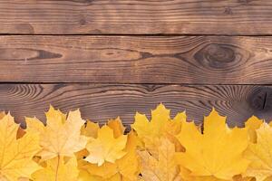 otoño hojas marco en de madera antecedentes parte superior ver otoño frontera amarillo y naranja hojas Clásico madera mesa Copiar espacio para texto. foto