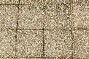 Pebble stone floor tile seamless background. Cement mixed gravel pebble stone floor texture. Wet round pebble stone rock floor in dramatic lighting. photo