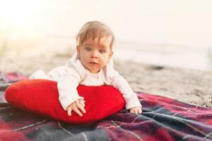 Baby girl lying on red blanket outdoor. Selective focus on her eyes. photo