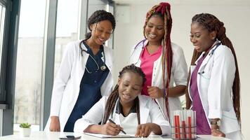 Young african american doctors have a discussion standing at a table while one of them makes notes video