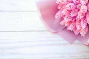 Beautiful bouquet of dry pink flowers on a wooden white background. Minimalism, space for text. Gift Card photo