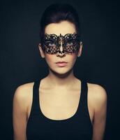 beautiful woman in black dress with black lace mask photo