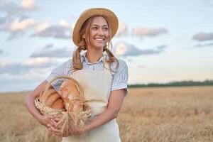 Female farmer standing wheat agricultural field Woman baker holding wicker basket bread product photo