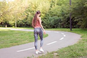 Beautiful athletic woman standing running track in summer park Portrait caucasian female jogger outdoor photo