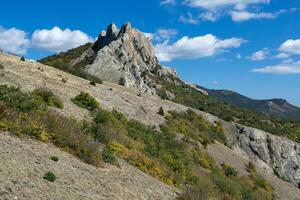 autumn landscape with yellow and green trees against mountains and the beautiful blue sky photo