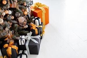 Christmas present box black, orange and white color on white floor with copy space photo