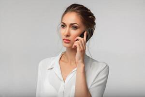 beautiful businesswoman with a cell phone in hands. serious conversation. business portrait photo