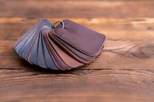 Leather samples for shoes on dark wooden table. photo