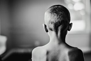 AI generated Young boy stands with his back to the camera photo