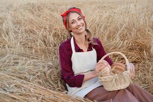 Female farmer sitting wheat agricultural field Woman baker holding wicker basket bread product photo