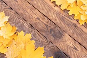 Autumn leaves frame on wooden background top view Fall Border yellow and Orange Leaves vintage wood table Copy space for text. photo