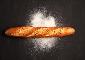 one crispy french baguettes lie on an old wooden table with free space for text photo