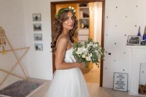 Wedding flowers in bride hands in interior bride in a designer dress holding flower bouquet photo