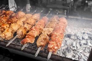 Grilled kebab cooking on metal skewer. Roasted meat cooked at barbecue. BBQ fresh beef meat chop slices. Traditional eastern dish, shish kebab. photo