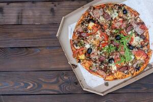 Appetizing pizza with smoked sausages bacon meat tomato cheese arugula photo