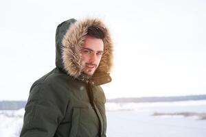 Attractive bearded man standing outdoors in winter season forest. photo