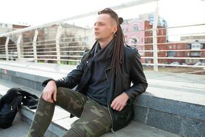 rocker rock star young man walking on the city street autumn day photo