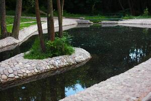 an artificial pond in the park topped stones photo
