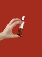 female hand holding nose spray photo