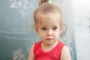 happy school girl on math classes in kindergarten finding solution and solving problems photo