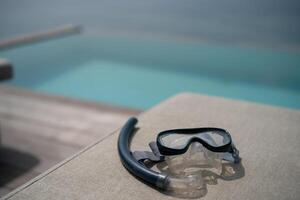 Snorkel and swimming mask lie on a gray pad background. photo