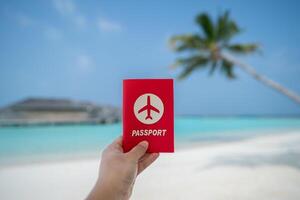 Hand holding passport with sea view background. photo