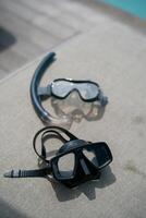 Snorkel and swimming mask lie on a gray pad background. photo