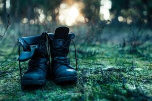 hiker old black boots standing on grass Hard travel concept photo