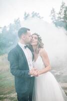 Beautiful bride and groom. Wedding ceremony in nature. Smoke bombs. photo