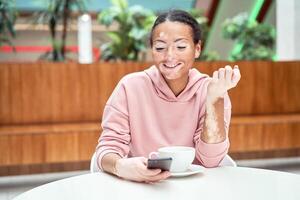 Black african american woman with vitiligo pigmentation skin problem indoor dressed pink hoodie photo