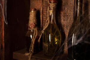 Víspera de Todos los Santos antecedentes estantería con alquimia herramientas cráneo telaraña botella con veneno velas foto