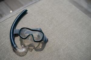 Snorkel and swimming mask lie on a gray pad background. photo