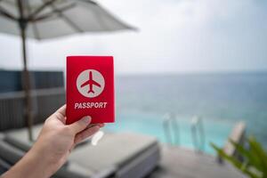 Hand holding passport with sea view background. photo