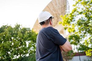 Engineer looking earth based astronomical radio telescope photo