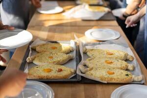 culinario Maestro clase. de cerca de personas manos preparando khachapuri. tradicional georgiano queso un pan. georgiano comida foto