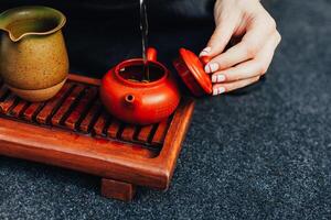 Traditional tea ceremony close up with woman hand photo