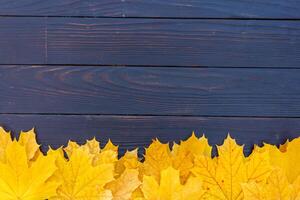 otoño hojas marco en de madera antecedentes parte superior ver otoño frontera amarillo y naranja hojas Clásico madera mesa Copiar espacio para texto. foto