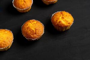 Appetizing muffins stand on a table top view. Traditional pastries on a dark background minimalism. photo