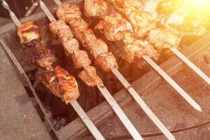 Grilled kebab cooking on metal skewer. Roasted meat cooked at barbecue. BBQ fresh beef meat chop slices. Traditional eastern dish, shish kebab. photo