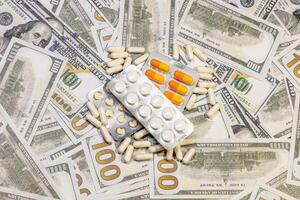 American currency banknote with medical drugs and dietary supplements in the form of tablets as a link to corruption in pharmaceuticals photo