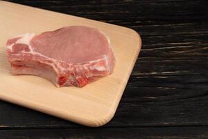 Top view of one pieces raw pork chop steaks on a cutting board. photo