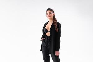 Young business woman arms crossed in black jacket standing studio isolated on white background photo