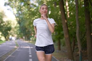 Woman running asphalt road summer park photo