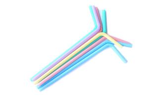 Colorful plastic drinking straws tubes for juice and cocktails, white background. Concept, single use equipment for drinking, but can use for diy crafts for decoration. photo